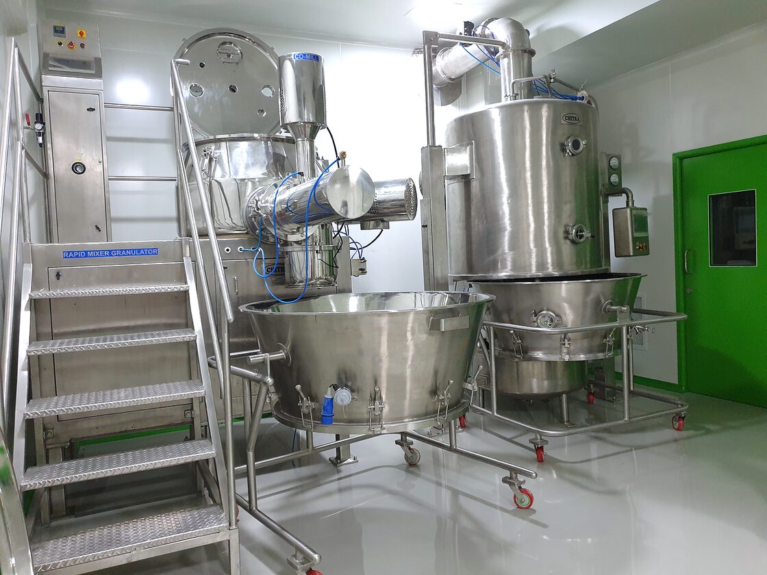 Granulation suite at the Naroda plant: a rapid mixer granulator and fluid bed dryer in stainless steel, inside a controlled area.